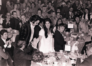 16 Jan 71 - Photo by Dave Darnell.  Elvis Presley (cq) and wife, Priscilla (cq) stand as he is introduced at a luncheon at the Holiday Inn Rivermont.  Presley was being honored by the Jaycees of America as one of the Outstanding Young Men In America.  Seated at left fore and applauding is William N. Morris (cq), former sheriff of Shelby County.  Seated and applauding to right of Priscilla (and staring at camera) is Red West.