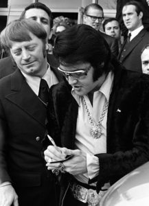 16 Jan 1971 - Photo by Dave Darnell.  Elvis Presley (cq) signs autographs for fans after leaving a luncheon at the Holiday Inn Rivermont.  At left is Red West (cq).  Behind West is William N. Morris (cq), former sheriff of Shelby County.  Presley was being honored by the Jaycees as one of the Outstanding Young Men In America.  This photograph appeared on Page One of The Commercial Appeal when Presley died in 1977.