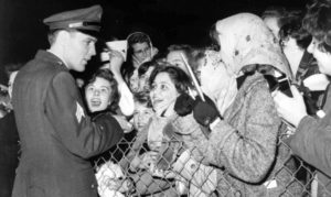 4th March 1960, Prestwick, Scotland, Sergeant Elvis Presley, American rock and roll singer, meets some of his screaming teenage fans who are there to greet him following his demobilization from the United States Army  (Photo by Popperfoto/Getty Images)